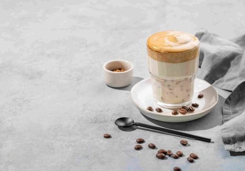 dalgona-coffee-whipped-instant-coffee-glass-with-coffee-beans-blue-background-with-napkin_2_11zon